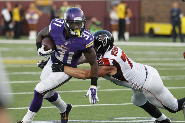 Minnesota Vikings running back Jerick McKinnon, left, tries to break a tackle by Atlanta Falcons outside linebacker Kroy Biermann, right, during the second half of an NFL football game, Sunday, Sept. 28, 2014, in Minneapolis. (AP Photo/Ann Heisenfelt)