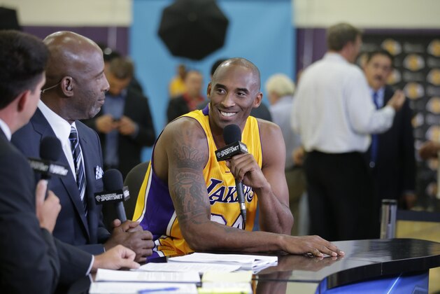 Los Angeles Lakers' Kobe Bryant, center, talks to former NBA star James Worthy during an interview on the team's NBA basketball media day Monday, Sept. 29, 2014, in El Segundo, Calif. (AP Photo/Jae C. Hong)
