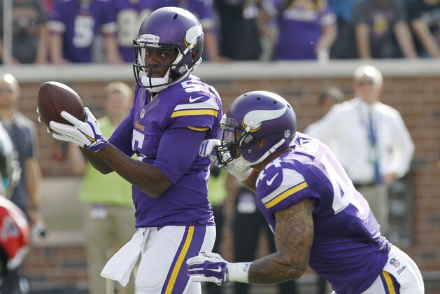 Minnesota Vikings quarterback Teddy Bridgewater, left, looks to hand the ball off to running back Matt Asiata during the first half of an NFL football game against the Atlanta Falcons, Sunday, Sept. 28, 2014, in Minneapolis. (AP Photo/Ann Heisenfelt)