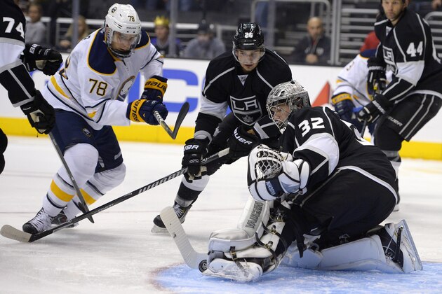 Los Angeles Kings goalie Jonathan Quick (32) stops a shot by Buffalo Sabres right wing Corey Tropp, left, as defenseman Slava Voynov, center of Russia, watches along with defenseman Robyn Regehr, of Brazil, during the first period of an NHL hockey game, Thursday, Nov. 7, 2013, in Los Angeles. (AP Photo/Mark J. Terrill)