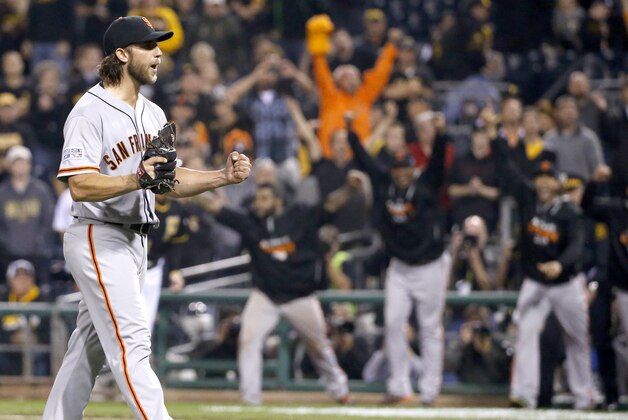 San Francisco Giants starting pitcher Madison Bumgarner starts to celebrate as teammates leave the dugout to join him after the last out against the Pittsburgh Pirates in the NL wild-card playoff baseball game Wednesday, Oct. 1, 2014, in Pittsburgh. The Giants won 8-0, advancing to a National League Division Series against the Washington Nationals. (AP Photo/Gene J. Puskar)