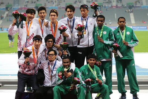 Japanese team members who won the gold, center South Korean team members who won the silver, left and Saudi Arabia team which won the bronze pose during the men's 4 x 400m relay medal ceremony at the 17th Asian Games in Incheon, South Korea,  Thursday, Oct. 2, 2014.(AP Photo/Rob Griffith)