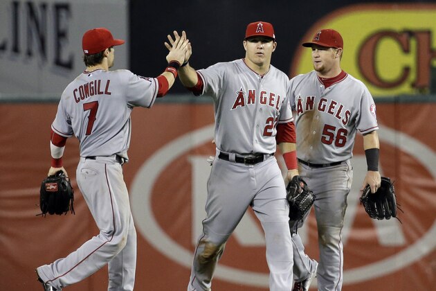Los Angeles Angels' Collin Cowgill (7), Mike Trout, and Kole Calhoun (56) celebrate after the Angels' 7-3 win over the Texas Rangers in a baseball game, Thursday, Sept. 11, 2014, in Arlington, Texas. (AP Photo/Tony Gutierrez)
