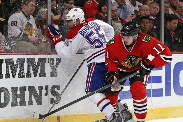 CHICAGO, IL - APRIL 09:  Francais Bouillon #55 of the Montreal Canadiens hits the boards as he chases the puck with Jeremy Morin #11 of the Chicago Blackhawks at the United Center on April 9, 2014  in Chicago, Illinois. The Blackhawks defeated the Canadiens 3-2 in overtime.  (Photo by Jonathan Daniel/Getty Images)