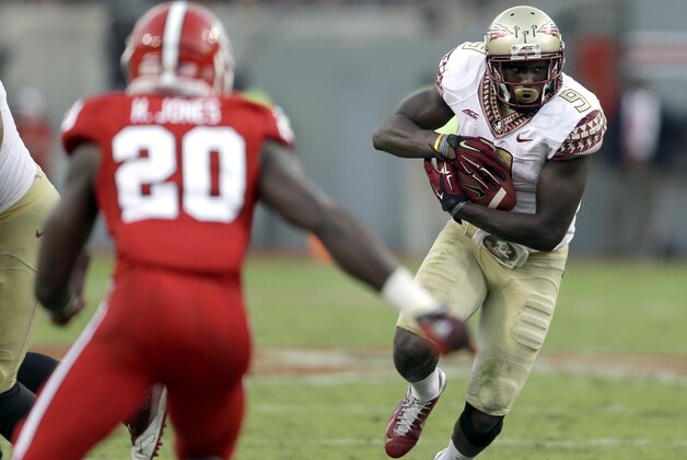 Florida State's Karlos Williams (9) runs the ball as North Carolina State's Hakim Jones (20) looks for the tackle during the second half of an NCAA college football game in Raleigh, N.C., Saturday, Sept. 27, 2014. Florida State won 56-41.(AP Photo/Gerry Broome)