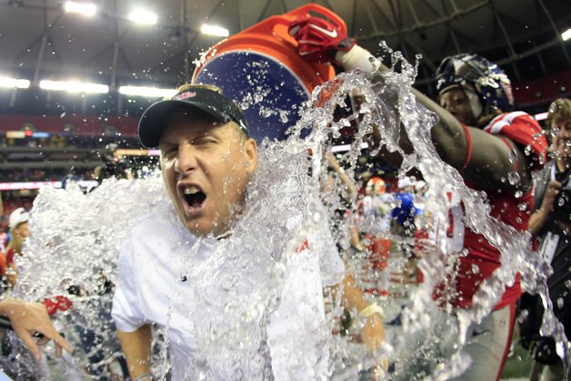 Aug 28, 2014; Atlanta, GA, USA; Mississippi Rebels head coach Hugh Freeze gets a victory dunk by his players following their win over the Boise State Broncos in the 2014 Chick-fil-a Kickoff Game at the Georgia Dome. The Rebels defeated the Broncos 35-13. Mandatory Credit: Paul Abell-USA TODAY Sports