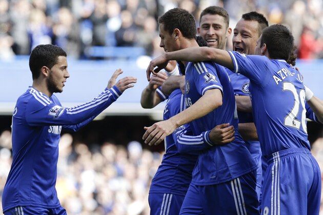 Chelsea's Mohamed Salah, hidden, is surrounded by team mates as he celebrates scoring a goal during the English Premier League soccer match between Chelsea and Arsenal at Stamford Bridge stadium in London, Saturday, March 22, 2014. (AP Photo/Kirsty Wigglesworth)