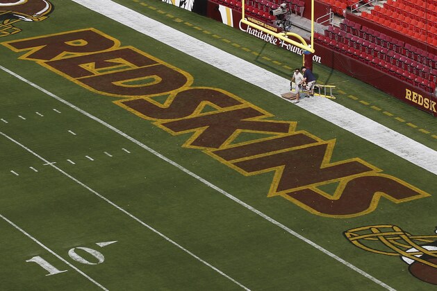 FILE - This Aug. 7, 2014 file photo shows groundskeepers preparing the end zone for the NFL football preseason game between the Washington Redskins and the New England Patriots in Landover, Md. The debate over the Washington Redskins nickname has been around for decades, usually as a flash-in-the-pan topic that pops up occasionally and disappears after a day or so. This time is different. The campaign against the term many consider to be a racial slur has reached sustained, unprecedented momentum over the last 18 months and shows no signs of abating. A confluence of events _ and several missteps by team owner Dan Snyder _ has made the issue a topic du jour. (AP Photo/Alex Brandon, File)