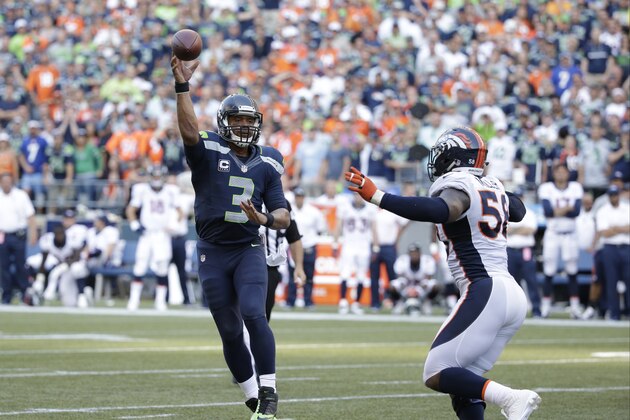 Seattle Seahawks quarterback Russell Wilson (3) passes under pressure from Denver Broncos outside linebacker Von Miller, right, in the second half of an NFL football game, Sunday, Sept. 21, 2014, in Seattle. (AP Photo/Elaine Thompson)