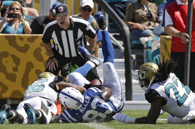 Indianapolis Colts tight end Dwayne Allen (83) scores a touchdown as Jacksonville Jaguars strong safety Josh Evans, left, and free safety Winston Guy (22) try to stop him as head linesman Jerry German, center, watches the play, during the first half of an NFL football game in Jacksonville, Fla., Sunday, Sept. 21, 2014. (AP Photo/Stephen B. Morton)
