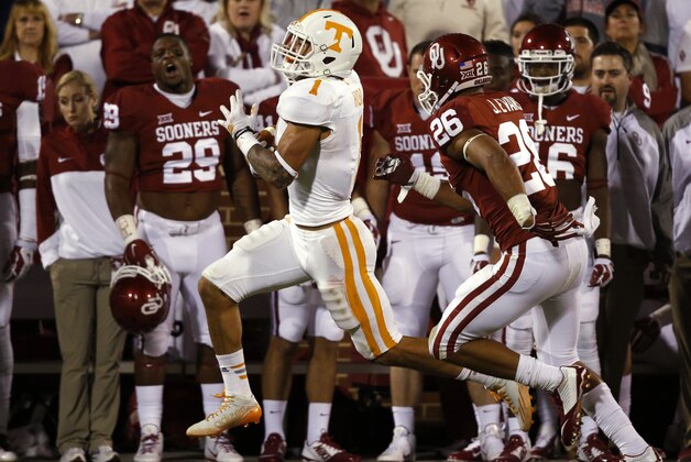 Tennessee running back Jalen Hurd (1) carries past the Oklahoma bench, pursued by Oklahoma linebacker Jordan Evans (26), during the third quarter of an NCAA college football game in Norman, Okla., Saturday, Sept. 13, 2014. Oklahoma won 34-10. (AP Photo/Sue Ogrocki)