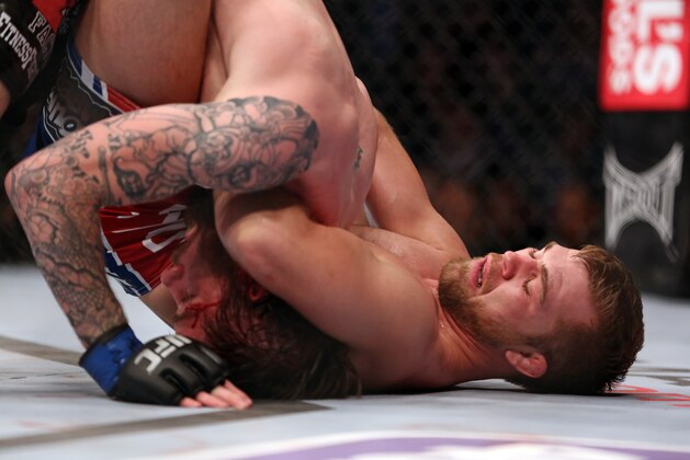 Bryan Caraway, right, sinks in the fight winning choke against Johnny Bedford during their UFC 159 Mixed Martial Arts bout in Newark, NJ, Saturday, April 27,2013.  Caraway won via third round submission via choke. (AP Photo/Gregory Payan)