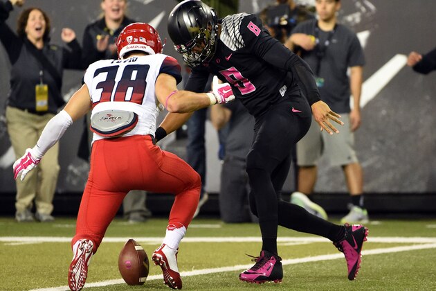 Oregon quarterback Marcus Mariota (8) scores a touchdown as Arizona Wildcats safety Jared Tevis (38) closes in during the second quarter of an NCAA college football game Thursday, Oct. 2, 2014, in Eugene, Ore. (AP Photo/Steve Dykes) Oregon quarterback Marcus Mariota (8) scores a touchdown as Arizona Wildcats safety Jared Tevis (38) closes in during the second quarter of an NCAA college football game Thursday, Oct. 2, 2014, in Eugene, Ore. (AP Photo/Steve Dykes)