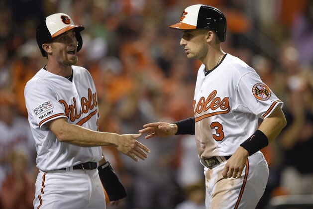 Baltimore Orioles' Ryan Flaherty (3) is met at the plate by J.J. Hardy (2) after they both scored on a double by Jonathan Schoop during the eighth inning against the Detroit Tigers Game 1 of baseball's AL Division Series, Thursday, Oct. 2, 2014, in Baltimore. (AP Photo/Nick Wass)