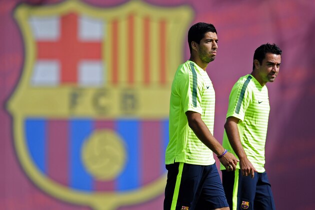 FC Barcelona's Luis Suarez, left, and Xavi Hernandez attend a training session at the Sports Center FC Barcelona Joan Gamper in San Joan Despi, Spain, Tuesday, Sept. 16, 2014. FC Barcelona will play against Apoel in a group F Champions League on Wednesday Sept. 17. (AP Photo/Manu Fernandez)