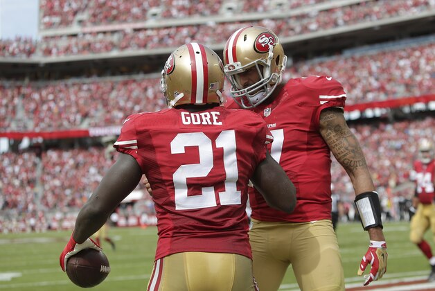 San Francisco 49ers running back Frank Gore (21) and quarterback Colin Kaepernick celebrate after connecting on a 55-yard touchdown reception against the Philadelphia Eagles during the second quarter of an NFL football game in Santa Clara, Calif., Sunday, Sept. 28, 2014. (AP Photo/Marcio Jose Sanchez)