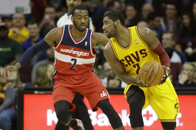 Washington Wizards' John Wall, left, guards Cleveland Cavaliers' Kyrie Irving in an NBA basketball game Sunday, Feb. 23, 2014, in Cleveland. (AP Photo/Mark Duncan)