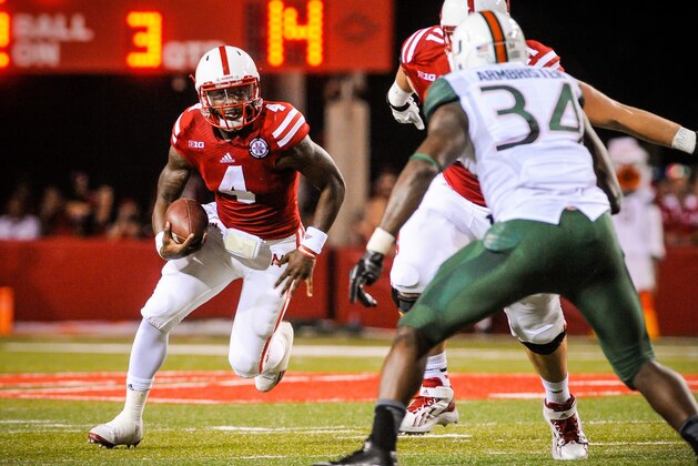 LINCOLN, NE - SEPTEMPER 20: Quarterback Tommy Armstrong Jr. #4 of the Nebraska Cornhuskers eyes linebacker Thurston Armbrister #34 of the Miami Hurricanes during their game at Memorial Stadium on September 20, 2014 in Lincoln, Nebraska. Nebraska defeated Miami 41-31. (Photo by Eric Francis/Getty Images)