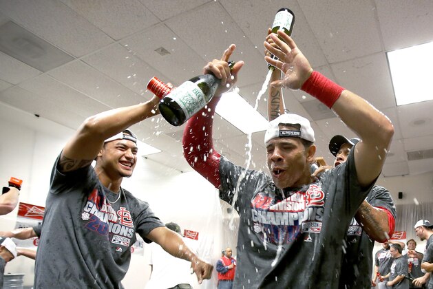 St. Louis Cardinals players celebrate after the Cardinals' baseball game against the Arizona Diamondbacks, Sunday, Sept. 28, 2014, in Phoenix. The Cardinals clinched their second straight NL Central title before the first pitch and closed out the regular season with a 1-0 win over the Diamondbacks. The Cardinals were already in the postseason entering the day and celebrated the division title in the dugout minutes before first pitch, when Cincinnati's 4-1 win over Pittsburgh was announced. (AP Photo/Rick Scuteri)