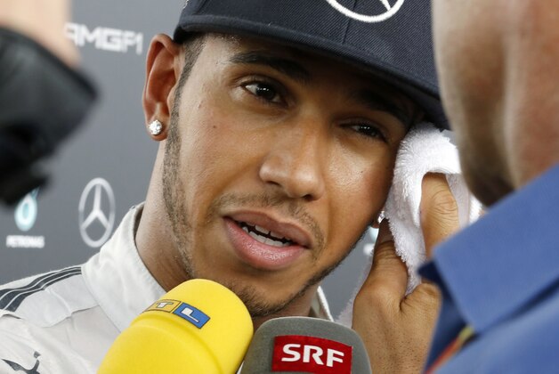 Mercedes driver Lewis Hamilton of Britain wipes his sweat while speaking to journalists after the second practice session for Sunday's Japanese Formula One Grand Prix at the Suzuka Circuit in Suzuka, central Japan, Friday, Oct. 3, 2014. Hamilton set the fastest time in practice for the Grand Prix on Friday, edging teammate and Formula One championship rival Nico Rosberg. (AP Photo/Toru Takahashi)
