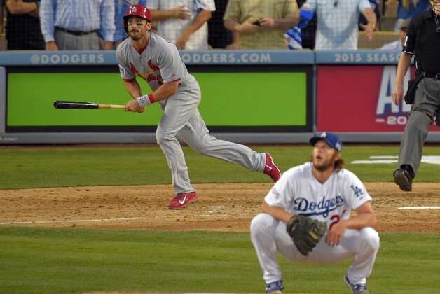 St. Louis Cardinals' Matt Carpenter, left, watches his a three-run double as Los Angeles Dodgers starting pitcher Clayton Kershaw, right, crouches on the mound in the seventh inning of Game 1 of baseball's NL Division Series in Los Angeles, Friday, Oct. 3, 2014. (AP Photo/Mark J. Terrill)