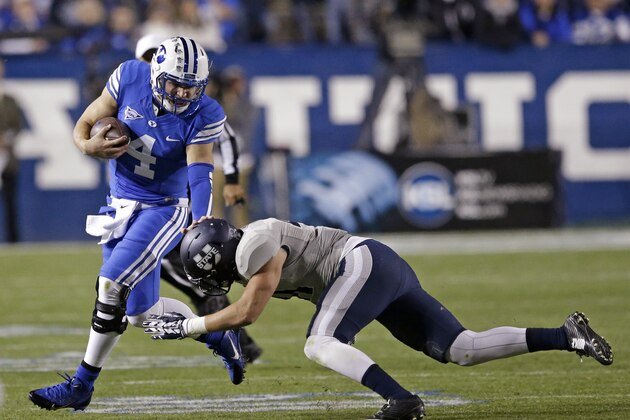 Utah State linebacker Nick Vigil tackles BYU quarterback Taysom Hill (4) in the first quarter during an NCAA college football game Friday, Oct. 3, 2014, in Provo, Utah. (AP Photo/Rick Bowmer)