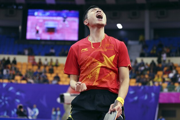 China’s Xu Xin reacts as he won a point against compatriot Fan Zhendong during their men's singles table tennis final match at Suwon Gymnasium at the 17th Asian Games in Suwon, South Korea, Saturday, Oct. 4, 2014. (AP Photo/Eugene Hoshiko)