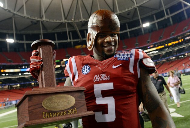 Aug 28, 2014; Atlanta, GA, USA; Mississippi Rebels defensive tackle Robert Nkemdiche (5) celebrates with the old leather helmet after defeating the Boise State Broncos in the 2014 Chick-fil-A kickoff game at the Georgia Dome. Rebels won 35-13. Mandatory Credit: John David Mercer-USA TODAY Sports