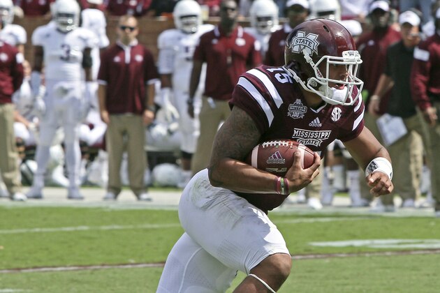 Mississippi State quarterback Dak Prescott (15) gains additional yardage after receiving a pass during the first half of an NCAA college football game against Texas A&M in Starkville, Miss., Saturday, Oct. 4, 2014. (AP Photo/Jim Lytle)