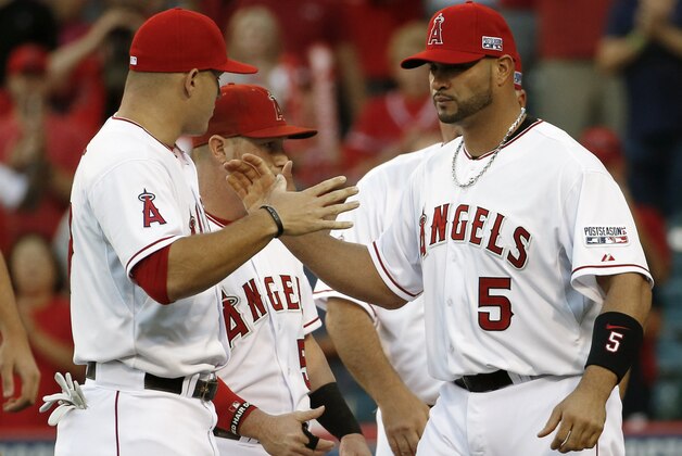 Los Angeles Angels first baseman Albert Pujols. right, and center fielder Mike Trout greet each other before facing the Kansas City Royals in baseball's Game 1 of the AL Division Series in Anaheim, Calif., Thursday, Oct. 2, 2014.  (AP Photo/Lenny Ignelzi)