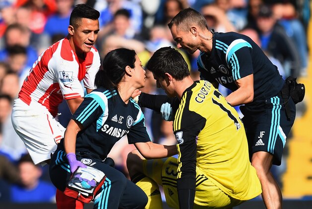 LONDON, ENGLAND - OCTOBER 05:  Thibaut Courtois of Chelsea is helped to his feet by Alexis Sanchez of Arsenal during the Barclays Premier League match between Chelsea and Arsenal at Stamford Bridge on October 4, 2014 in London, England.  (Photo by Shaun Botterill/Getty Images)