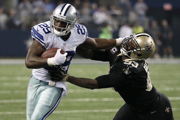 Dallas Cowboys running back DeMarco Murray (29) fights off a tackle attempt by New Orleans Saints' Junior Galette (93)during the second half of an NFL football game, Sunday, Sept. 28, 2014, in Arlington, Texas. (AP Photo/Brandon Wade)