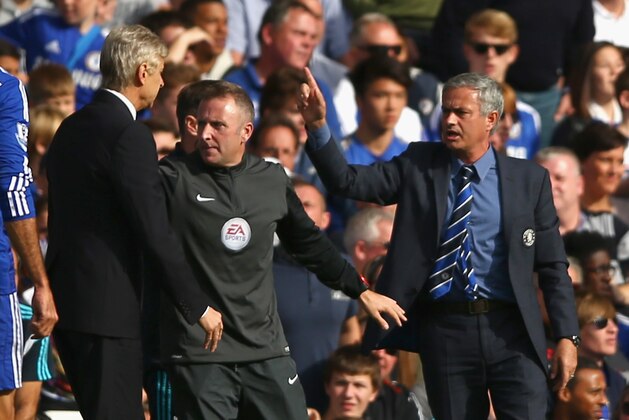 LONDON, ENGLAND - OCTOBER 05:  Fourth Official Jonathan Moss comes between Managers Arsene Wenger of Arsenal and Jose Mourinho manager of Chelsea during the Barclays Premier League match between Chelsea and Arsenal at Stamford Bridge on October 4, 2014 in London, England.  (Photo by Paul Gilham/Getty Images)