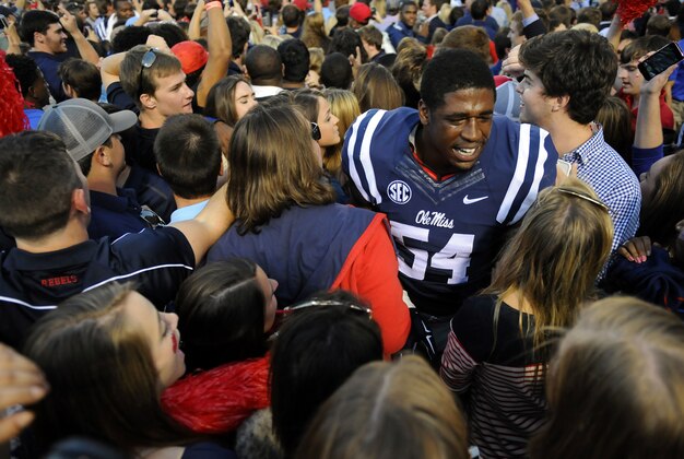 Oct 4, 2014; Oxford, MS, USA; Mississippi Rebels fans celebrate with defensive end Carlos Thompson (54) after a win against the Alabama Crimson Tide at Vaught-Hemingway Stadium. The Rebels won 23-17. Mandatory Credit: Christopher Hanewinckel-USA TODAY Sports