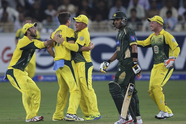Pakistani batsman Shahid Afridi walks off the pitch as the Australian players celebrate during the International T20 match between Australia and Pakistan in Dubai, United Arab Emirates, Sunday, Oct. 5, 2014. (AP Photo/Kamran Jebreili)
