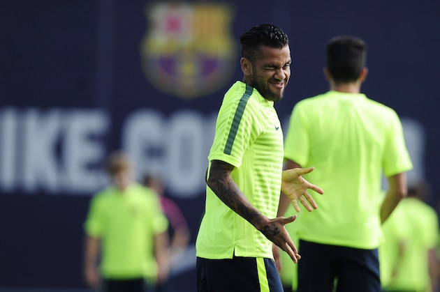 FC Barcelona's Dani Alves winks during a training session at the Sports Center FC Barcelona Joan Gamper in San Joan Despi, Spain, Tuesday, Sept. 16, 2014. FC Barcelona will play against Apoel in a group F Champions League on Wednesday Sept. 17. (AP Photo/Manu Fernandez)