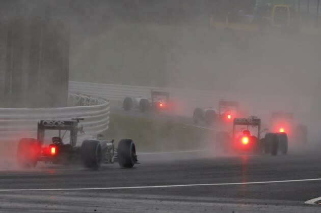 Formula One cars race in the rain during the Japanese F1 Grand Prix at the Suzuka Circuit in Suzuka, central Japan, Sunday, Oct. 5, 2014. (AP Photo/Toru Takahashi)