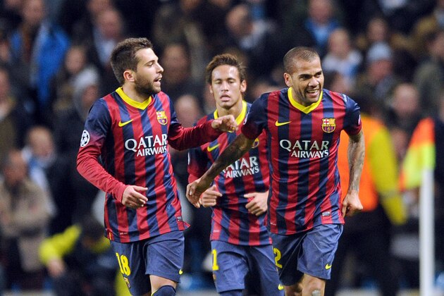 Barcelona's Daniel Alves, right, celebrates with teammate Jordi Alba, left, after he scored the second goal of the game for his side during their Champions League Round of 16 soccer match against Manchester City at the Etihad Stadium in Manchester, England, Tuesday, Feb. 18, 2014. (AP Photo/Clint Hughes)