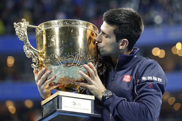 Novak Djokovic of Serbia kisses his trophy after he won over Tomas Berdych of Czech Republic in the men's singles final at China Open tennis tournament at the National Tennis Stadium in Beijing, China, Sunday, Oct. 5, 2014. (AP Photo/Vincent Thian)