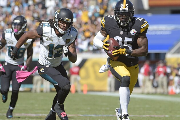 Pittsburgh Steelers cornerback Brice McCain, right, returns an intercepted pass 22-yards for a touchdown in front of Jacksonville Jaguars wide receiver Mike Brown (12) during the second half of an NFL football game in Jacksonville, Fla., Sunday, Oct. 5, 2014. (AP Photo/Phelan M. Ebenhack)