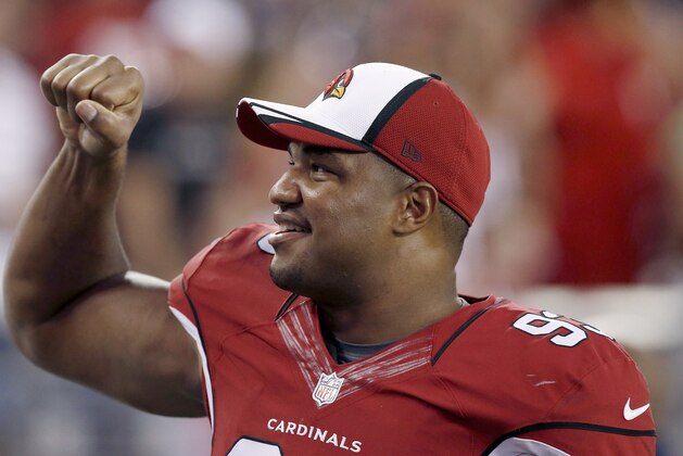 Arizona Cardinals' Calais Campbell smiles as he pumps his fist to cheering fans during the first half of an NFL preseason football game against the Houston Texans Saturday, Aug. 9, 2014, in Glendale, Ariz.  The Cardinals defeated the Texans 32-0. (AP Photo/Ross D. Franklin)