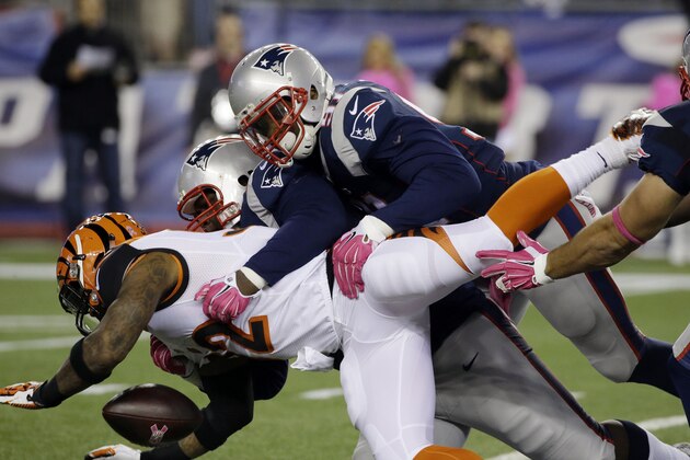 New England Patriots defenders Jamie Collins, top, and Casey Walker, rear, tackle Cincinnati Bengals running back Jeremy Hill (32) in the first half of an NFL football game Sunday, Oct. 5, 2014, in Foxborough, Mass. (AP Photo/Stephan Savoia)