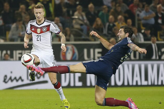Germany’s Marco Reus, left, and Scotland’s Grant Hanley challenge for the ball during the Euro 2016 soccer qualifying group D match between Germany and Scotland in Dortmund, Germany, Sunday, Sept. 7, 2014. (AP Photo/Frank Augstein)