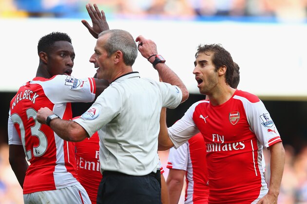 LONDON, ENGLAND - OCTOBER 05:  Danny Welbeck  and Mathieu Flamini of Arsenal surround Referee Martin Atkinson during the Barclays Premier League match between Chelsea and Arsenal at Stamford Bridge on October 4, 2014 in London, England.  (Photo by Paul Gilham/Getty Images)