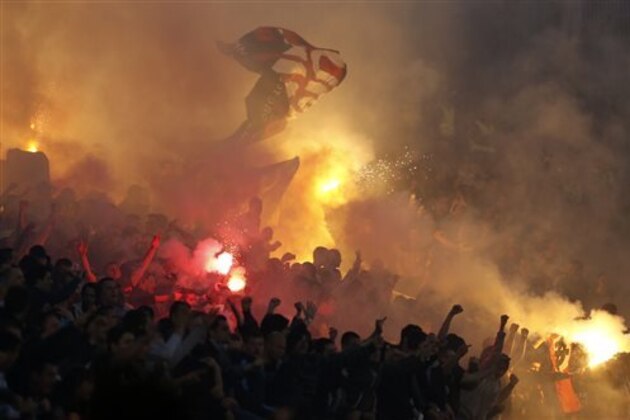 AP10thingsToSee - Fans use signal flares and flags to cheer for the Partizan team during a Serbian National soccer league derby match against Red Star in Belgrade, Serbia, Saturday, April 26, 2014. (AP Photo/Darko Vojinovic)