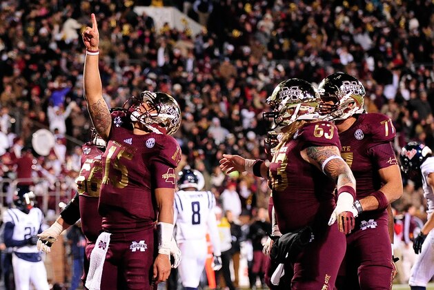 STARKVILLE, MS - NOVEMBER 28:  Dak Prescott #15 of the Mississippi State Bulldogs celebrates a touchdown in overtime against the Ole Miss Rebels during a game at Davis Wade Stadium on November 28, 2013 in Starkville, Mississippi.  Mississippi State won the game 17-10.  (Photo by Stacy Revere/Getty Images)
