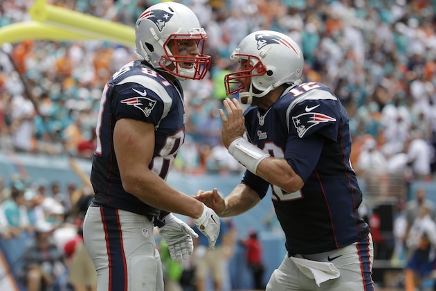 New England Patriots quarterback Tom Brady (12) celebrates a touchdown with New England Patriots tight end Rob Gronkowski (87) during the first half of an NFL football game against the Miami Dolphins, in Miami Gardens, Fla., Sunday Sept. 7, 2014. (AP Photo/Lynne Sladky)