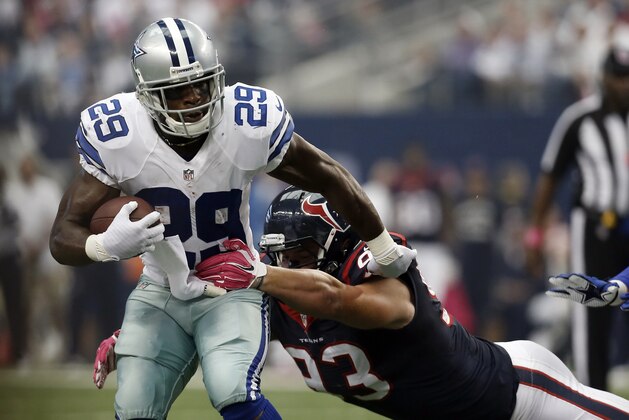 Dallas Cowboys' DeMarco Murray (29) attempts to escape a tackle by Houston Texans defensive end Jared Crick (93) during the first half of an NFL football game, Sunday, Oct. 5, 2014, in Arlington, Texas. (AP Photo/Brandon Wade)