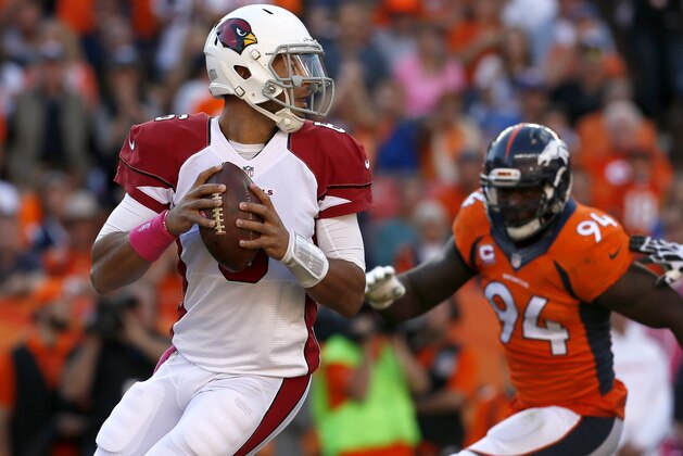 Arizona Cardinals quarterback Logan Thomas looks to pass under pressure from Denver Broncos defensive end DeMarcus Ware (94) during the second half of an NFL football game, Sunday, Oct. 5, 2014, in Denver. (AP Photo/Joe Mahoney)