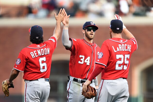 SAN FRANCISCO, CA - OCTOBER 06:  Bryce Harper #34 celebrates with Anthony Rendon #6 and Adam LaRoche #25 of the Washington Nationals after their 4 to 1 win over the San Francisco Giants during Game Three of the National League Division Series at AT&T Park on October 6, 2014 in San Francisco, California.  (Photo by Thearon W. Henderson/Getty Images)